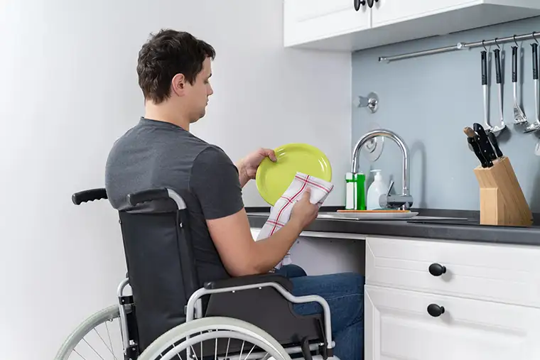 NDIS Participant in wheelchair using accessible kitchen after home modification Perth
